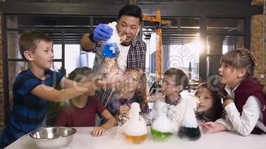 年轻的亚洲科学家-老师在课堂上为孩子们做干冰实验。 在实验期间，教师举行